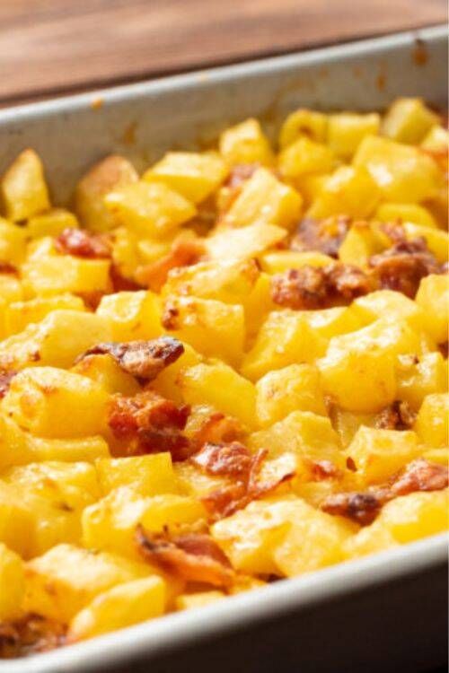 Loaded cheesy potatoes with crispy bacon bits and green onions on a golden baked potato base